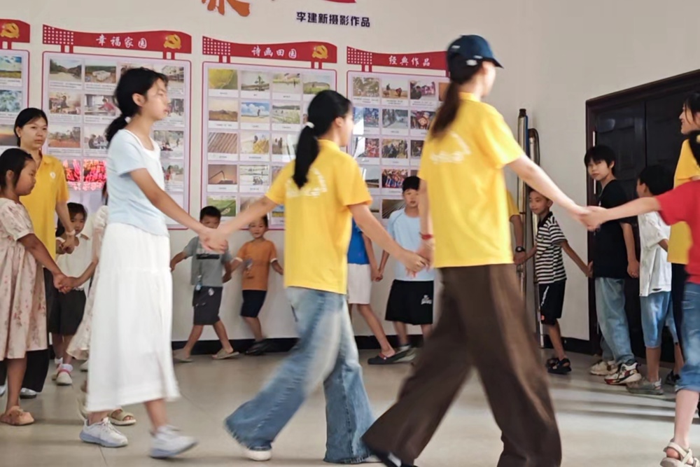 图1：图为队员组织孩童开展集体趣味游戏