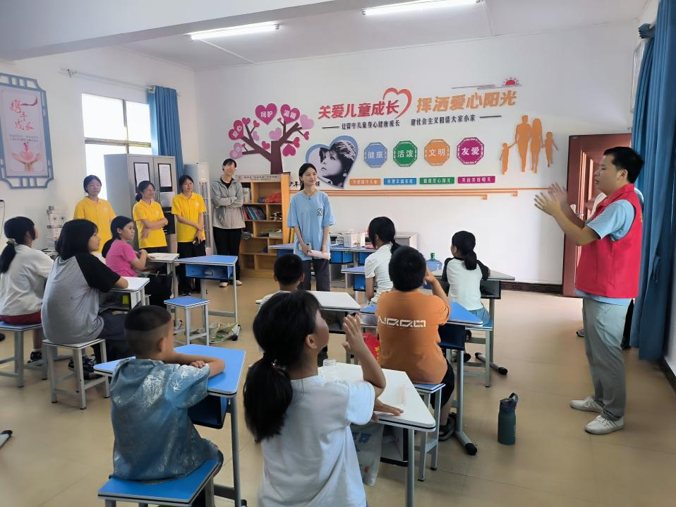 图片1 图为团队成员与留守儿童互动