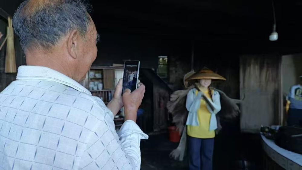 图二：图为老支书主动拿出手机为团队成员拍照留念