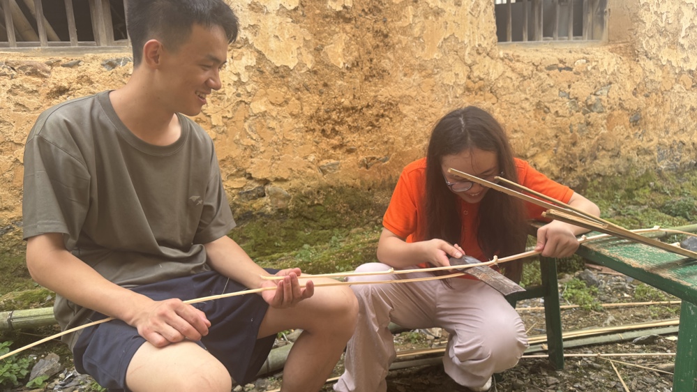 图2：图为队员在村野博主朱雄飞的指导下学习破篾