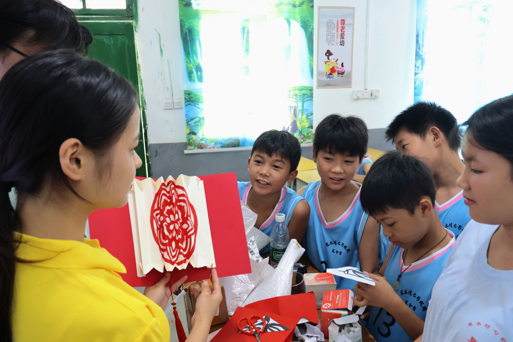 图1志愿者耐心指导孩童制作花灯