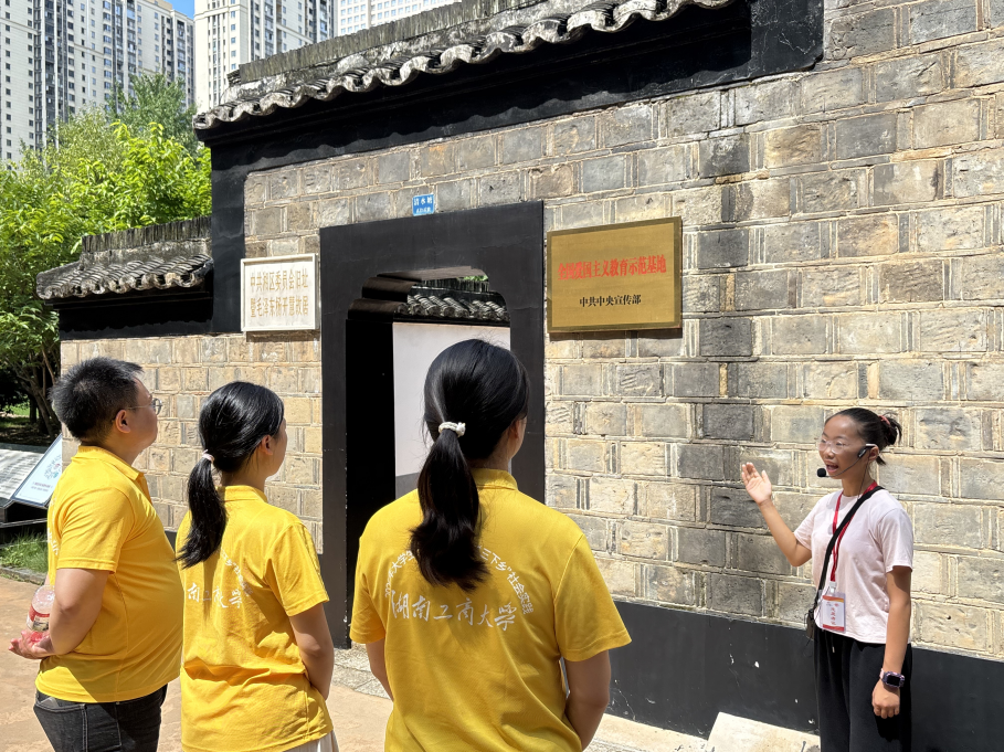 图为实践团在旧址外聆听“红领巾”讲解员细致讲解