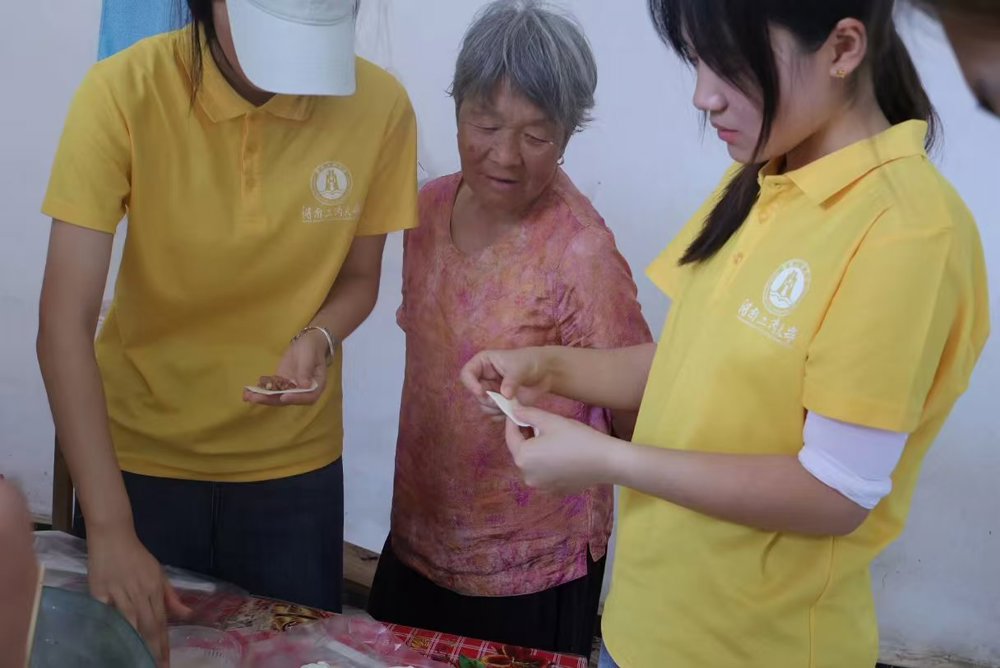 图1：图为团队成员与农户奶奶一起包黄花菜饺子