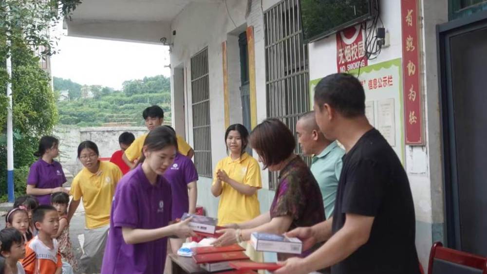 第二张：图为爱心人士与学校领导发放奖品