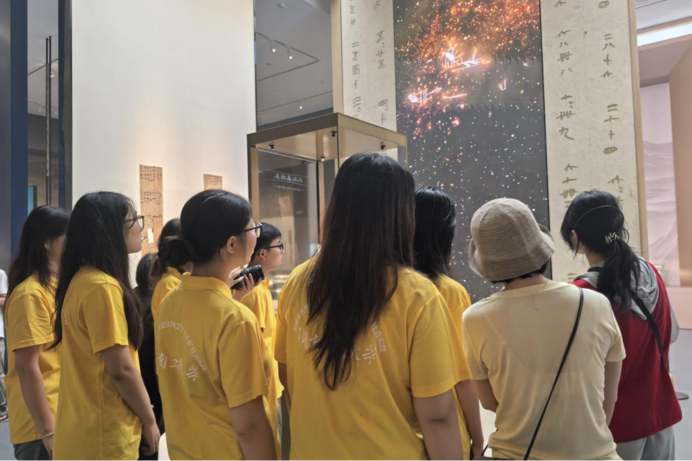 图2：图为调研团成员与游客一同观看数字化技术展示