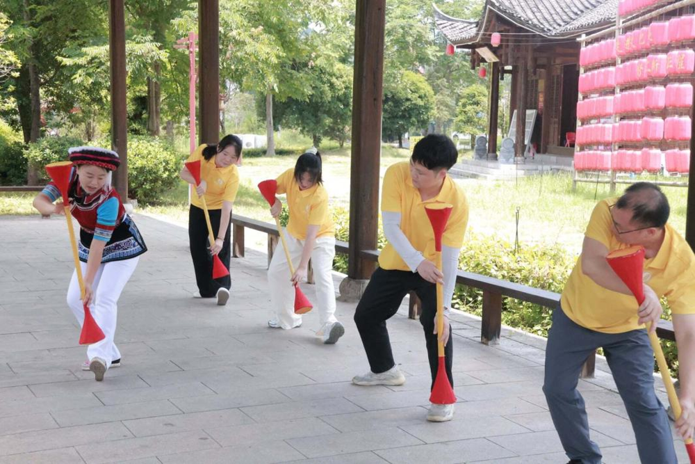 图3：图为实践团成员体验学习白族传统民俗文化
